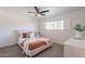 Serene bedroom with natural light, featuring a ceiling fan, carpet, and white wooden shutters at 726 W El Camino W Dr, Phoenix, AZ 85021