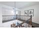 Bright hallway with dark floors, an ornate railing, and artwork at 726 W El Camino W Dr, Phoenix, AZ 85021