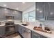 Modern kitchen with gray cabinets, white backsplash, and stainless steel appliances at 726 W El Camino W Dr, Phoenix, AZ 85021