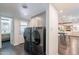 Modern laundry room with gray cabinets, high-end washer and dryer, and access to a stylish bathroom at 726 W El Camino W Dr, Phoenix, AZ 85021