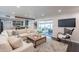 Bright living room with a view of the patio, a modern TV, and a cozy seating area at 726 W El Camino W Dr, Phoenix, AZ 85021