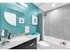 Stylish bathroom with a turquoise accent wall, round mirror, and combined bathtub/shower at 7400 E Gainey Club Dr # 123, Scottsdale, AZ 85258