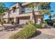 Inviting townhouse exterior featuring a two-car garage and mature landscaping at 7400 E Gainey Club Dr # 123, Scottsdale, AZ 85258