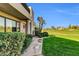 Beautiful front yard with green lawn, palm trees, and views of a golf course at 7400 E Gainey Club Dr # 123, Scottsdale, AZ 85258