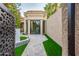 Private backyard oasis featuring a tiled courtyard, outdoor seating area, and lush artificial turf at 8401 N 84Th Pl, Scottsdale, AZ 85258