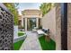 Private backyard oasis showcasing a tiled courtyard, lounge seating, and lush artificial turf at 8401 N 84Th Pl, Scottsdale, AZ 85258