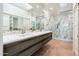 Modern primary bathroom boasts a double sink vanity, marble shower, stylish fixtures, and skylights for natural light at 8401 N 84Th Pl, Scottsdale, AZ 85258
