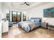 This primary bedroom features travertine flooring, tray ceiling and sliding glass doors to the backyard and outdoor space at 8401 N 84Th Pl, Scottsdale, AZ 85258