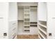 A custom walk-in closet is outfitted with open shelving, drawers, and rods for optimal organization and storage at 8401 N 84Th Pl, Scottsdale, AZ 85258