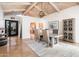 Open concept dining room featuring wood beam ceiling, view of entry, and arched passthrough to the kitchen at 8401 N 84Th Pl, Scottsdale, AZ 85258