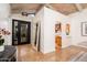 Welcoming entryway featuring travertine tile, a modern front door, arched pass-throughs, and natural light at 8401 N 84Th Pl, Scottsdale, AZ 85258