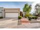Inviting home with a two-car garage, desert landscaping, and a colorful flowering vine near the entryway at 8401 N 84Th Pl, Scottsdale, AZ 85258