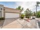 Southwestern home showcasing a two-car garage, desert landscaping, and a lush green lawn at 8401 N 84Th Pl, Scottsdale, AZ 85258