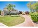 Charming courtyard with lush lawn, mature trees, and brick-paved pathway leading to the inviting home at 8401 N 84Th Pl, Scottsdale, AZ 85258