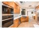 Well-appointed kitchen features custom cabinetry, stainless steel appliances, and natural light from the atrium window at 8401 N 84Th Pl, Scottsdale, AZ 85258