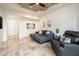 Comfortable living room with tray ceiling, travertine floors, and a modern gray sofa with chaise lounge at 8401 N 84Th Pl, Scottsdale, AZ 85258