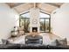Bright living room featuring a stone fireplace, vaulted ceilings, and large windows overlooking the outdoor space at 8401 N 84Th Pl, Scottsdale, AZ 85258