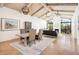 Bright living room with wood beam ceiling, fireplace, large windows, and an open concept design with the dining area at 8401 N 84Th Pl, Scottsdale, AZ 85258