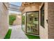 Inviting patio with travertine tile, custom shade structure, and a view of the dining area through a large bay window at 8401 N 84Th Pl, Scottsdale, AZ 85258