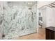 An elegant shower with a glass enclosure showcases marble walls, pebble flooring, and modern chrome fixtures at 8401 N 84Th Pl, Scottsdale, AZ 85258