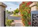 Scenic street view through a beautiful gate with vibrant red flowers and desert landscaping at 8401 N 84Th Pl, Scottsdale, AZ 85258