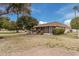 Charming backyard featuring a well-maintained lawn, mature trees, and a covered patio at 9202 N 107Th Ave, Sun City, AZ 85351