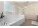 Bright bathroom featuring a large soaking tub, glass shower, and neutral tones at 9544 E Theia Dr, Mesa, AZ 85212