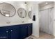 Stylish bathroom featuring navy blue vanity with double sinks, and modern lighting at 9544 E Theia Dr, Mesa, AZ 85212
