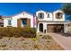 Charming two-story home featuring a red tile roof, stone landscaping, and a three-car garage at 9544 E Theia Dr, Mesa, AZ 85212