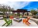 Community firepit and lounge area with pergola, colorful Adirondack chairs, and landscape, ideal for outdoor relaxation at 9544 E Theia Dr, Mesa, AZ 85212