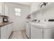Bright laundry room with white cabinets, butcher block counters, washer and dryer at 9544 E Theia Dr, Mesa, AZ 85212