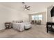 Bright and airy main bedroom with a ceiling fan, seating area, and scenic window view at 9544 E Theia Dr, Mesa, AZ 85212