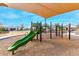 Bright, fun playground with a green slide, climbing structure and sunshades, set among neighborhood landscaping and homes at 9544 E Theia Dr, Mesa, AZ 85212