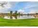 Picturesque pond surrounded by a lush green lawn and mature trees in a well maintained community at 9544 E Theia Dr, Mesa, AZ 85212