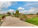 Scenic community walking path featuring lush landscaping, mature trees, and a pedestrian bridge on a bright sunny day at 9544 E Theia Dr, Mesa, AZ 85212
