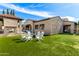 Expansive backyard featuring well manicured artificial grass, a fire pit, outdoor cooking area, and cozy seating at 9834 E Voltaire Dr, Scottsdale, AZ 85260