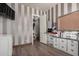 Stylish bedroom with striped walls, hardwood floors, and custom built-in storage solutions at 9834 E Voltaire Dr, Scottsdale, AZ 85260