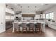 Bright kitchen featuring a large island with seating, custom cabinets, and stainless steel appliances at 9834 E Voltaire Dr, Scottsdale, AZ 85260