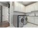 Well-lit laundry room featuring modern appliances, white cabinets, stone countertops, and stylish flooring at 9834 E Voltaire Dr, Scottsdale, AZ 85260