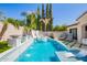Beautiful pool with slide, spa, and water feature; complemented by lush, tropical landscaping at 9834 E Voltaire Dr, Scottsdale, AZ 85260