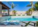 Modern pool with spa, fountains, slide and tiled surround with a covered outdoor sitting area at 9834 E Voltaire Dr, Scottsdale, AZ 85260