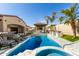 Beautiful pool and spa area with an outdoor kitchen, bar seating, and lush landscaping at 9834 E Voltaire Dr, Scottsdale, AZ 85260