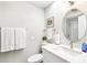 Bright bathroom with a round mirror, white sink, and white toilet at 9926 W Lancaster Dr, Sun City, AZ 85351