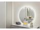 Modern bathroom features a stylish round mirror and vanity area providing a bright and welcoming atmosphere at 9926 W Lancaster Dr, Sun City, AZ 85351