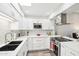 Contemporary kitchen with white cabinetry, sleek stainless-steel appliances, and modern countertop at 9926 W Lancaster Dr, Sun City, AZ 85351