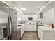Modern kitchen with stainless refrigerator, white cabinets, tile backsplash and a skylight at 9926 W Lancaster Dr, Sun City, AZ 85351
