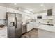 Updated kitchen with stainless steel refrigerator, modern white cabinetry, and stylish backsplash at 9926 W Lancaster Dr, Sun City, AZ 85351