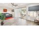 Cozy living room with hardwood floors, a ceiling fan, and sliding glass doors at 9926 W Lancaster Dr, Sun City, AZ 85351