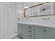 Modern bathroom features a double vanity, framed mirror, and a shower with vertical tiling at 1049 S Exeter St, Chandler, AZ 85286