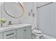 Charming bathroom featuring a blue vanity, gold mirror and patterned shower curtain at 1049 S Exeter St, Chandler, AZ 85286